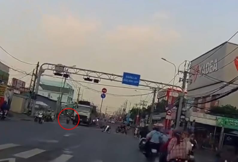 Đèn vừa chuyển xanh, 2 em HS chạy lên trước đầu xe tải, đúng ngay điểm khuất